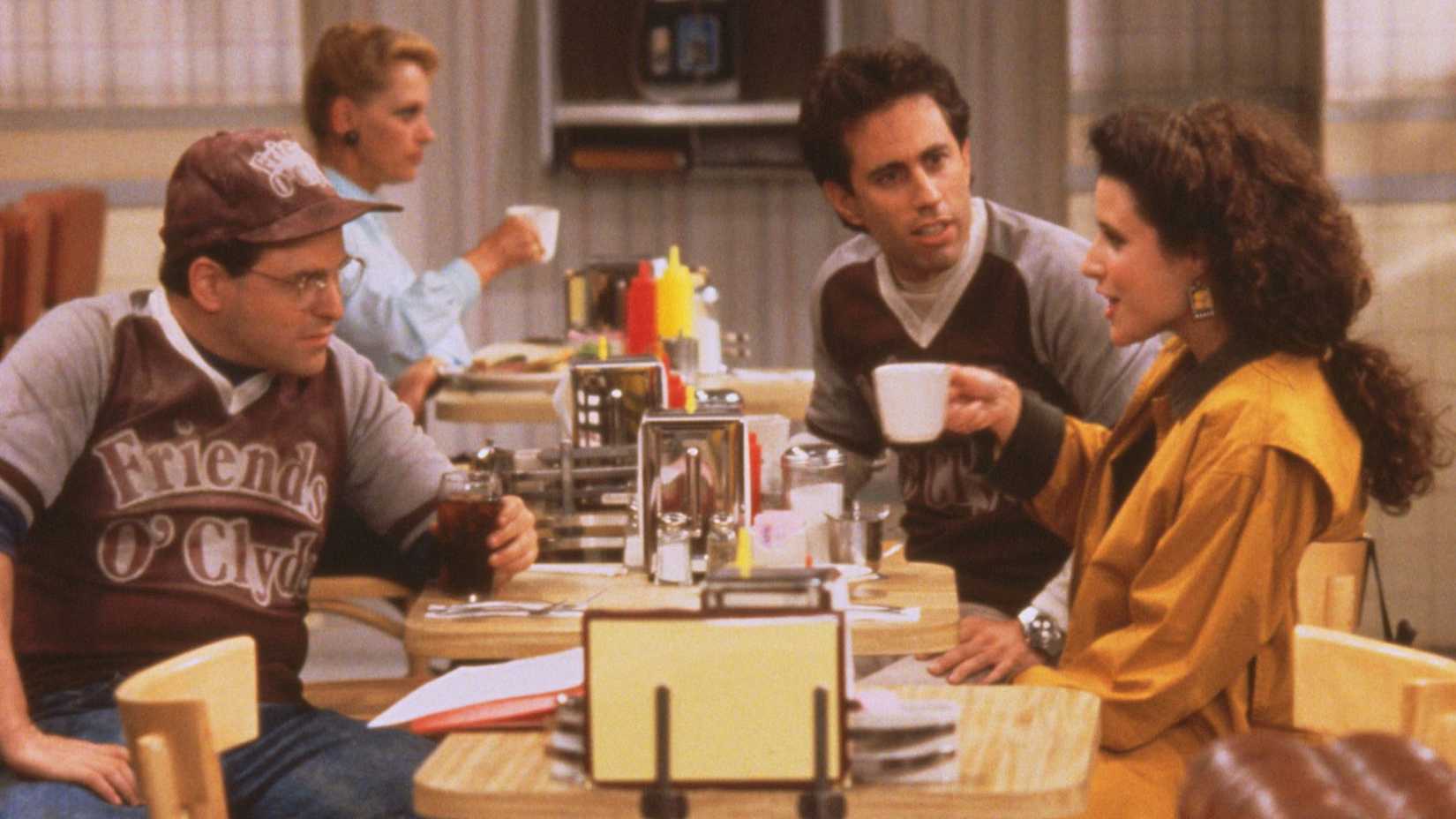 O elenco de Seinfeld sentado em uma mesa de lanchonete em Seinfeld: O Comentário do Pônei.