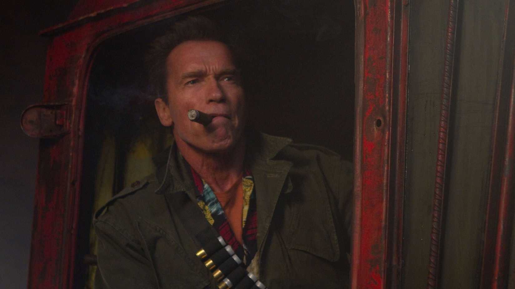 Arnold Schwarzenegger’s 10 Highest-Grossing Movies 2 Trench smokes a cigar in The Expendables 2