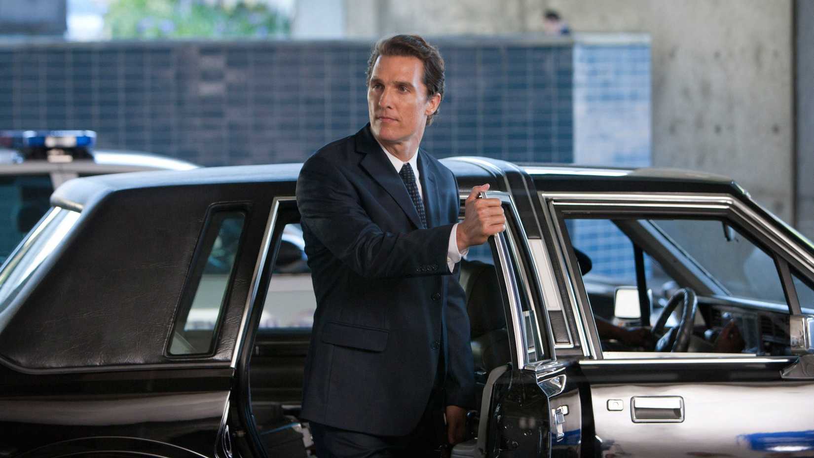 Matthew McConaughey's Mickey Haller stands in front of a Lincoln car in The Lincoln Lawyer movie