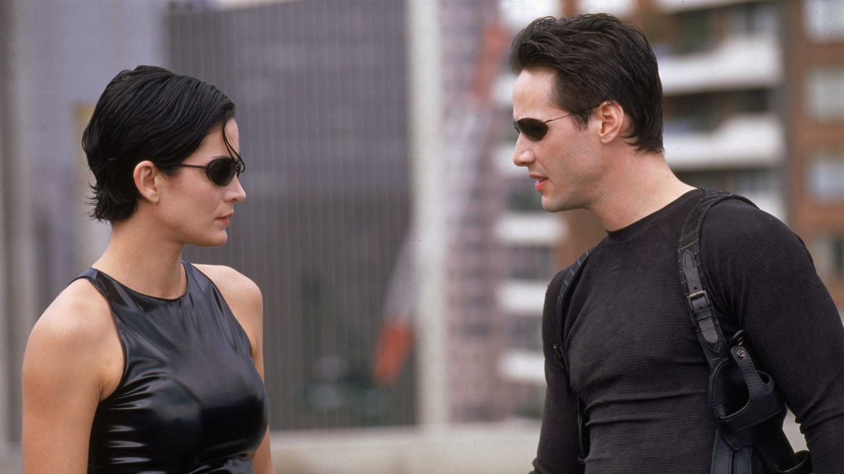 Keanu Reeves and Carrie-Ann Moss looking at each other in The Matrix