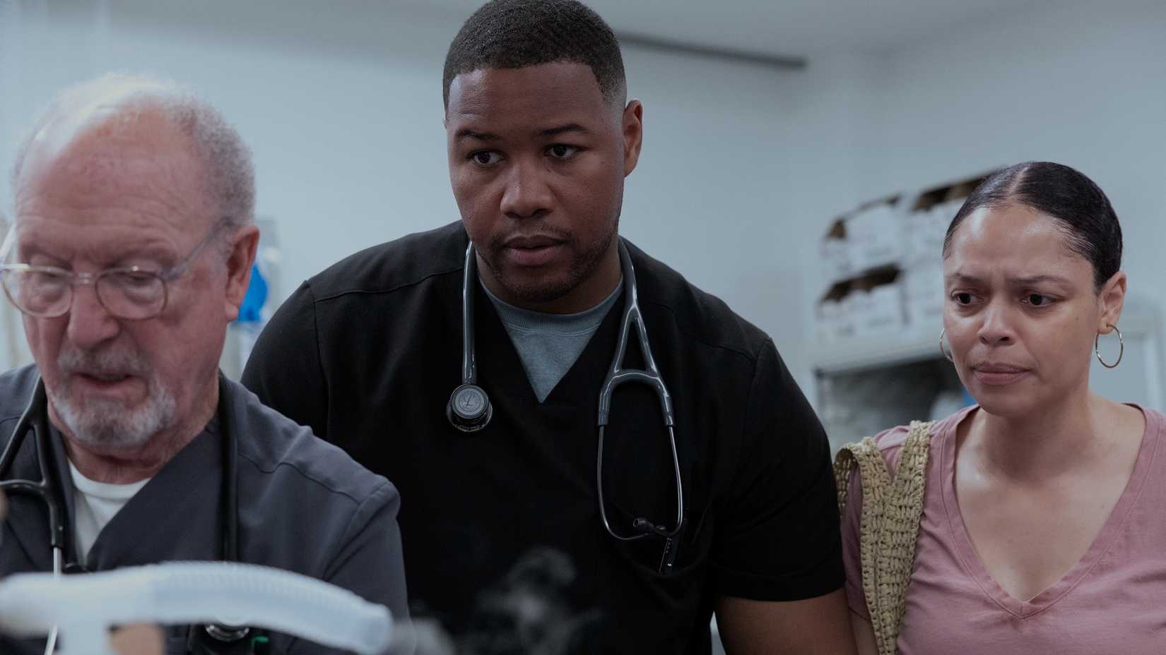 Dr. Crus Henderson Looking at a Patient in The Pitt Season 2