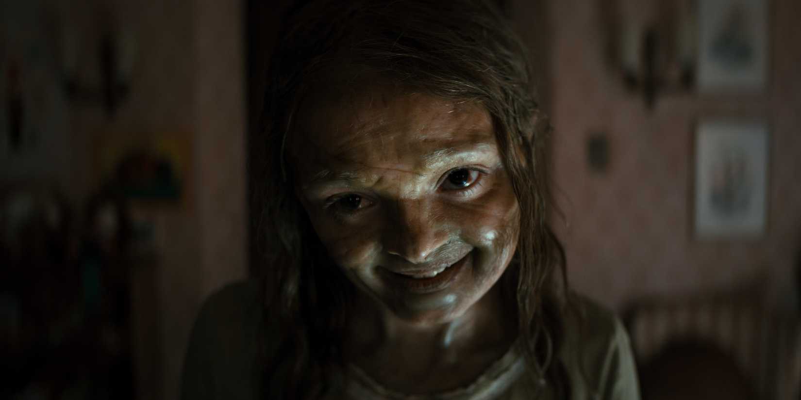 A garota possuída sorrindo em The Mummy de Lee Cronin