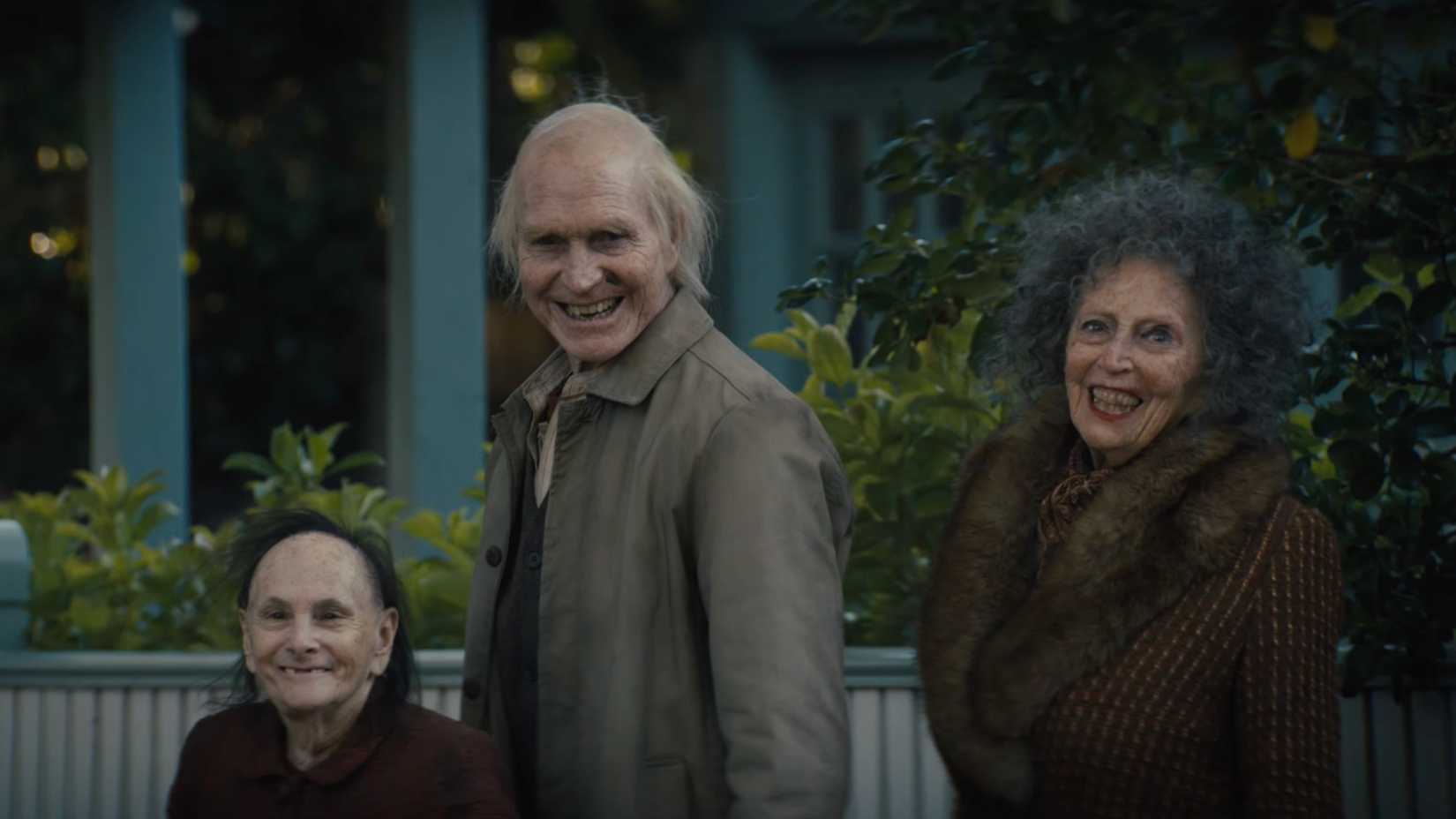 Três figuras assustadoras sorrindo em Insidious: O Portal do Medo