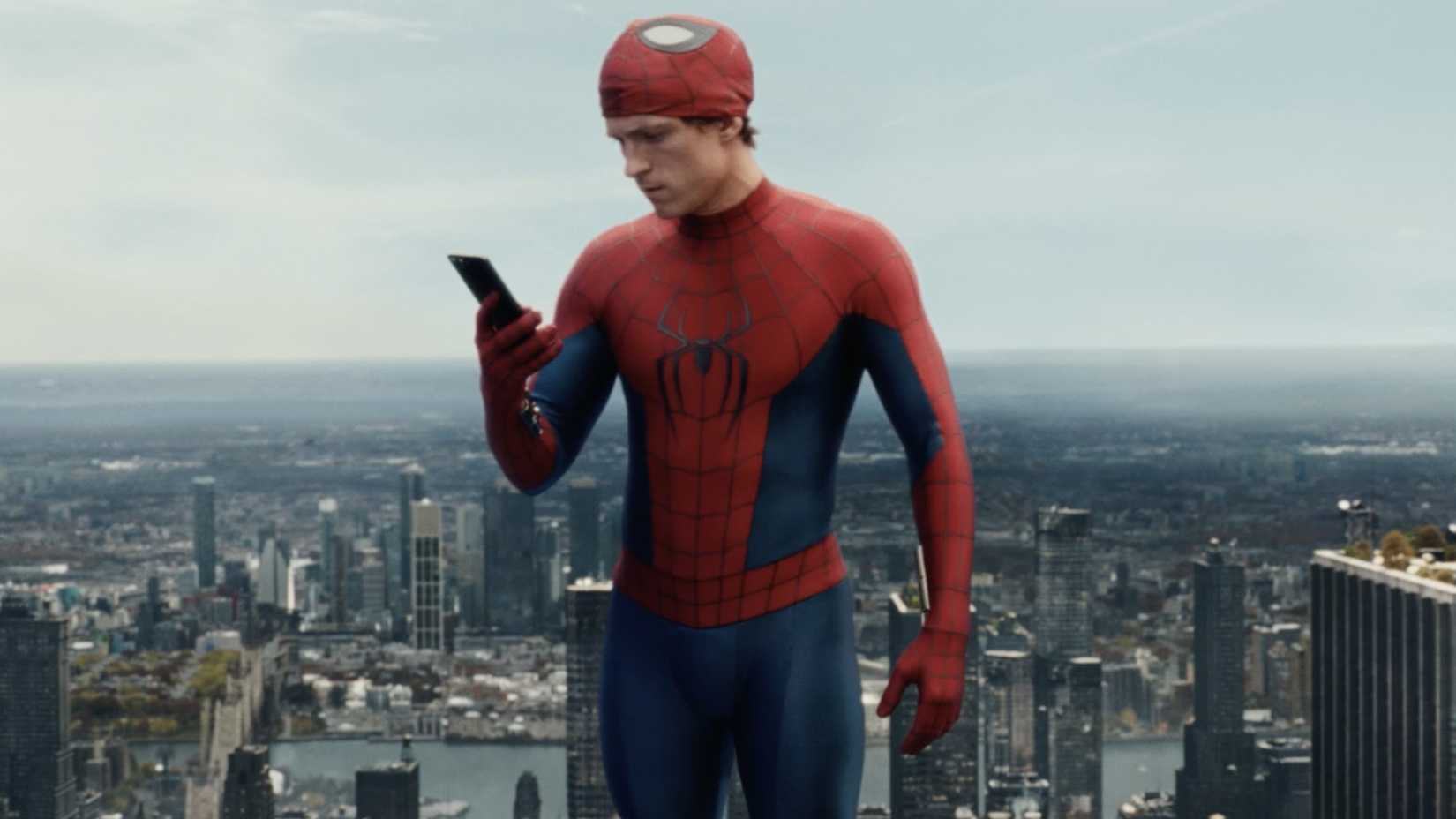 Tom Holland como Homem-Aranha em Brand New Day olhando para o celular