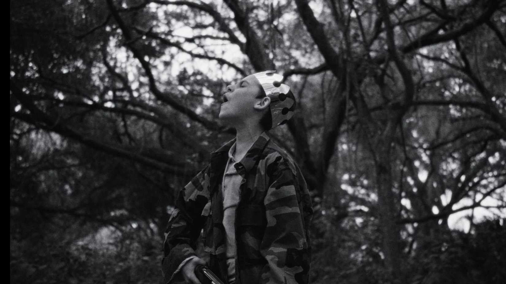 A character howls while wearing a paper crown