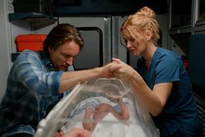 Jack and Mel hold hands over their baby while in the ambulance in Virgin River season 7 episode 10