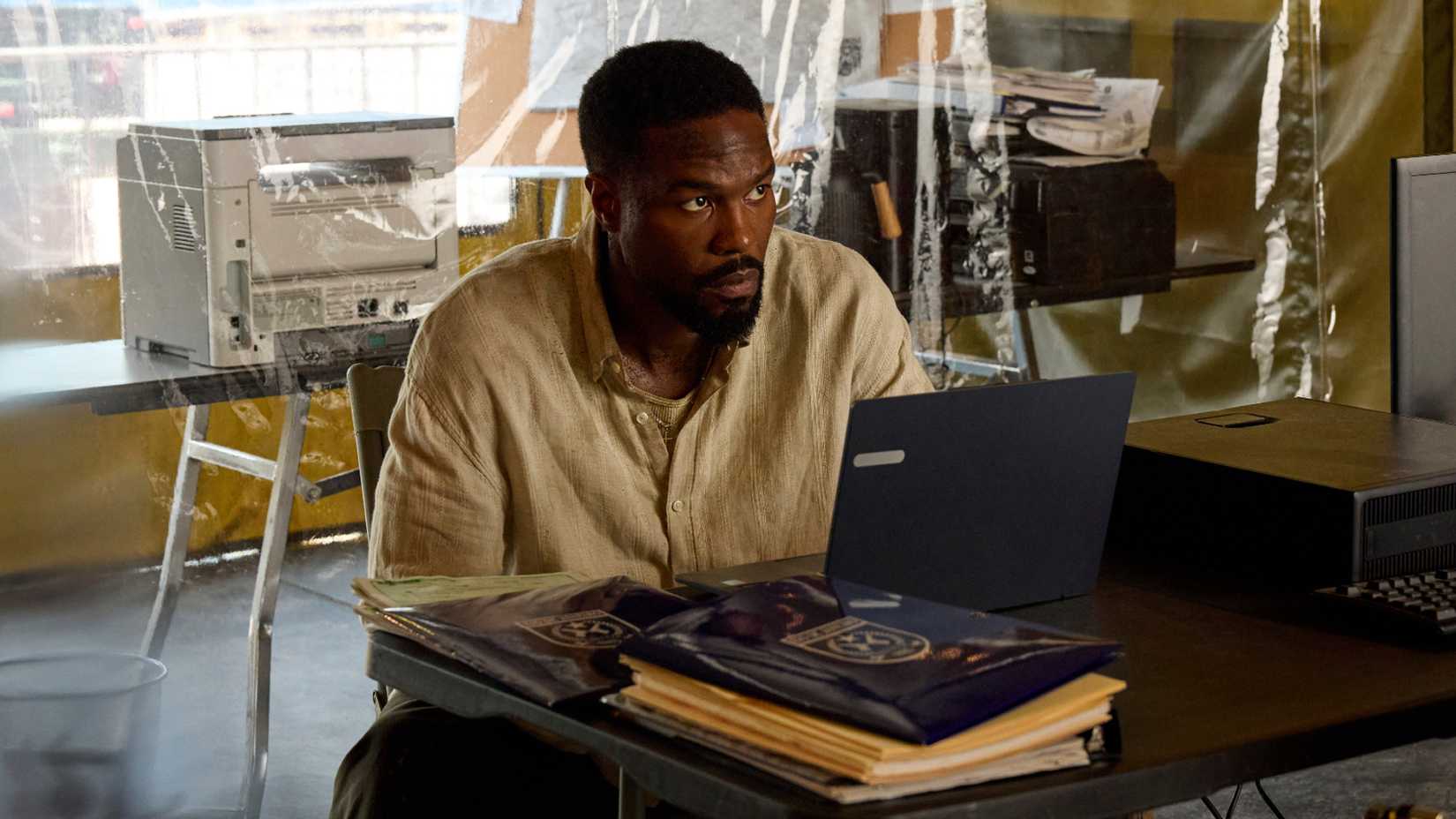 Yahya Abdul-Mateen II as John Creasy sitting at a computer looking anxious in Man on Fire