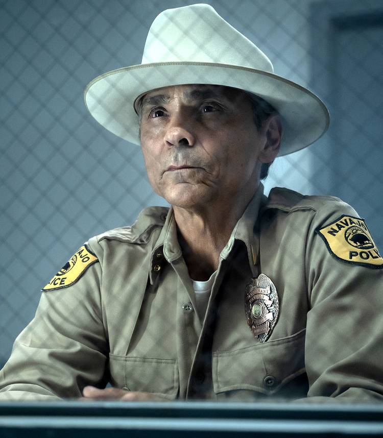 Zahn McClarnon's Leaphorn sitting proudly behind interview glass in Dark Winds season 4