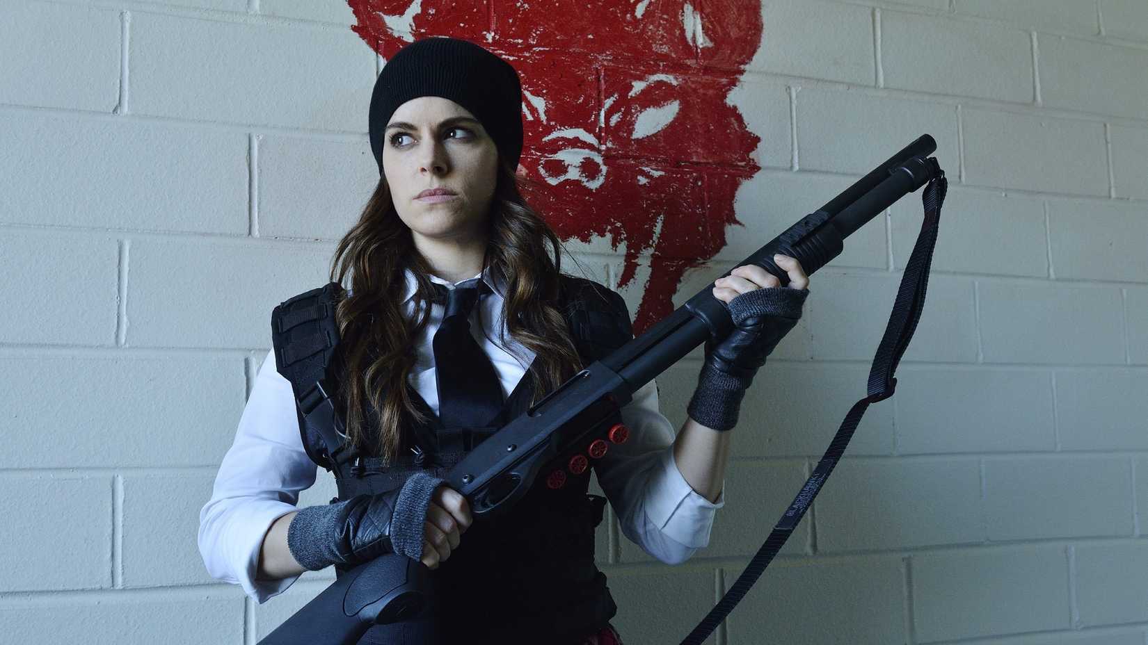 Emily Hampshire as Jennifer Goines holding a shotgun in 12 Monkeys