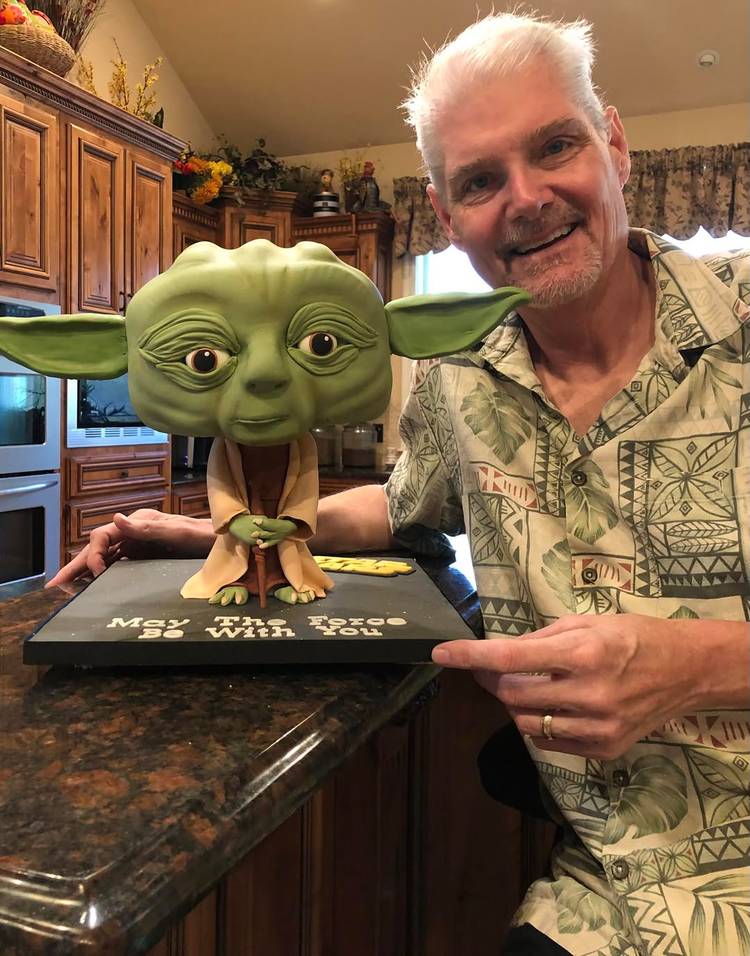 Tom Kane ao lado de um bolo temático do Mestre Yoda