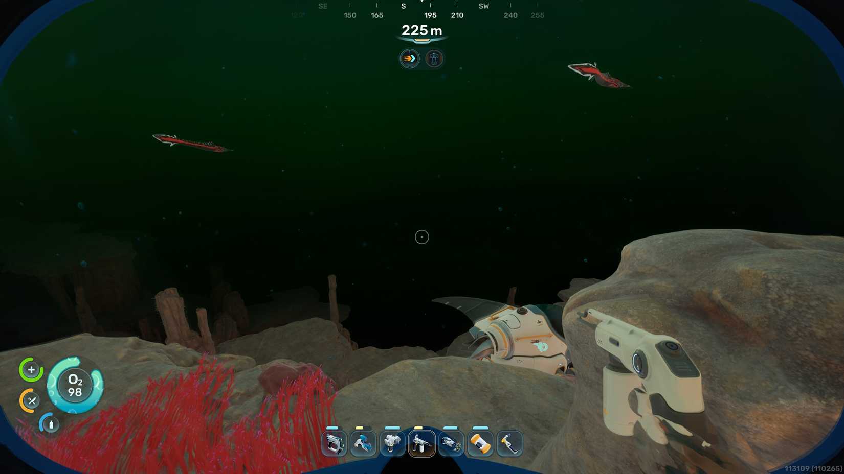 A player holding a repair tool approaches a Tadpole wedged into a rock wall near red seaweed while two Needlers swim above them in Subnautica 2