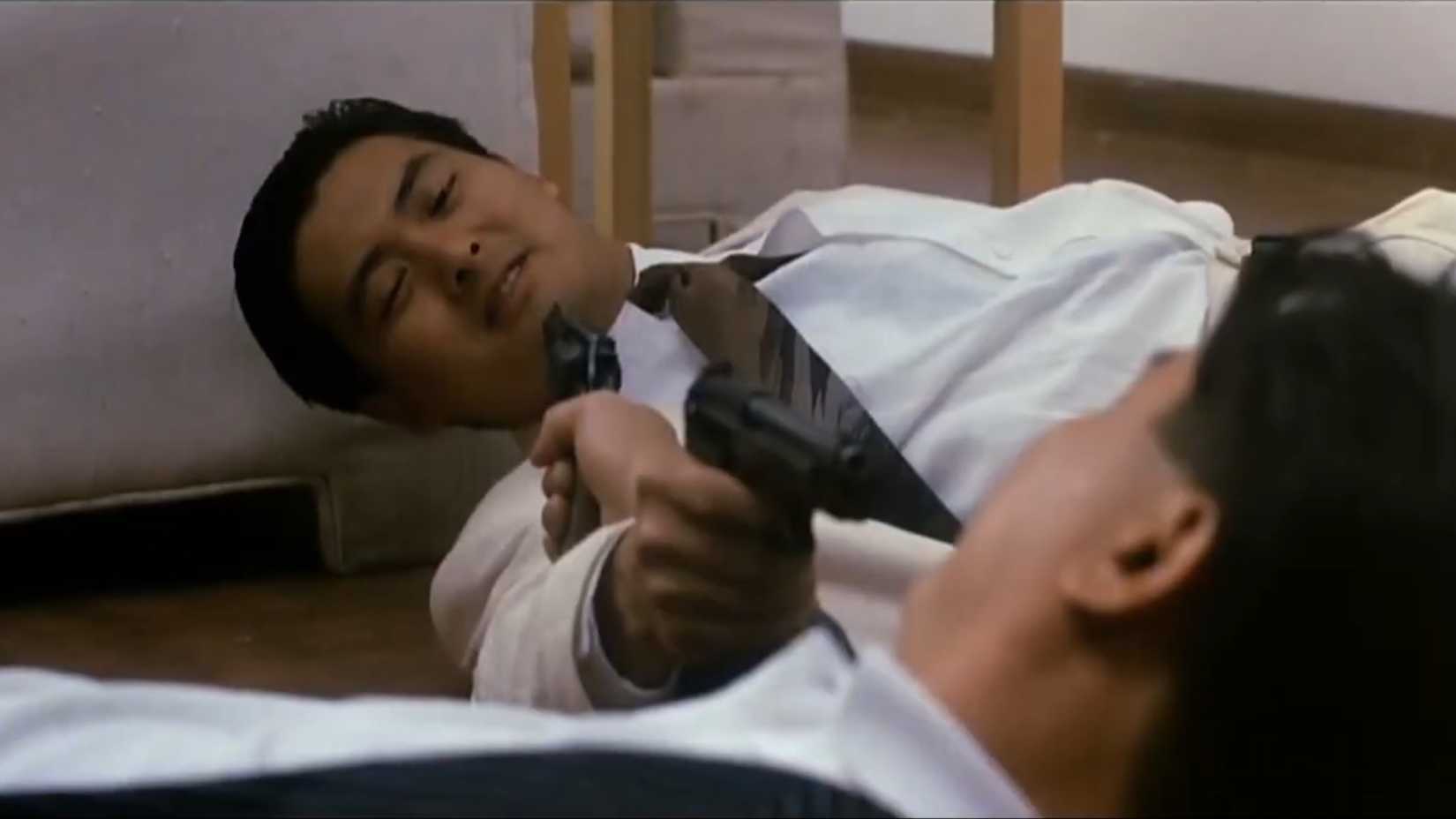 Ah Jong (Chow Jun Fat) and Yee Ling (Danny Lee) aiming pistols at each other in The Killer