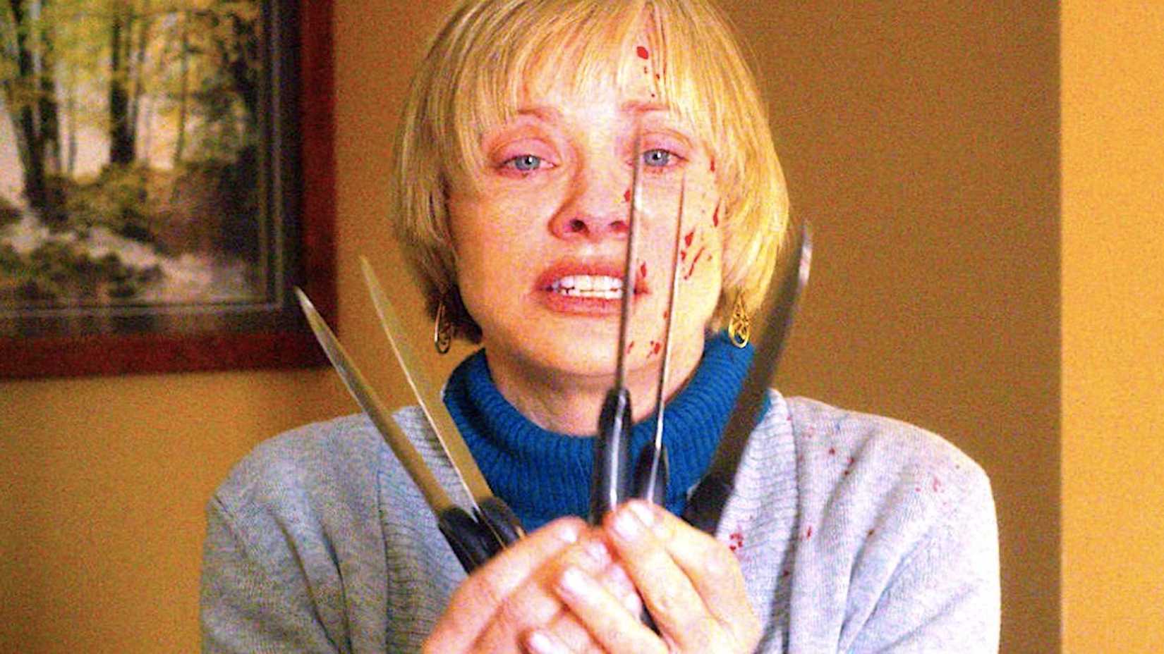 Anne holding up several knives in We Are Still Here