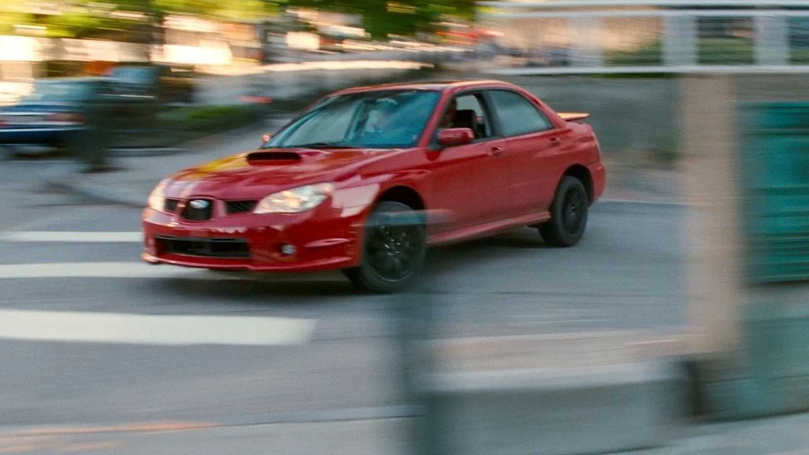 Baby sliding a red car into a highstreet in Baby Driver