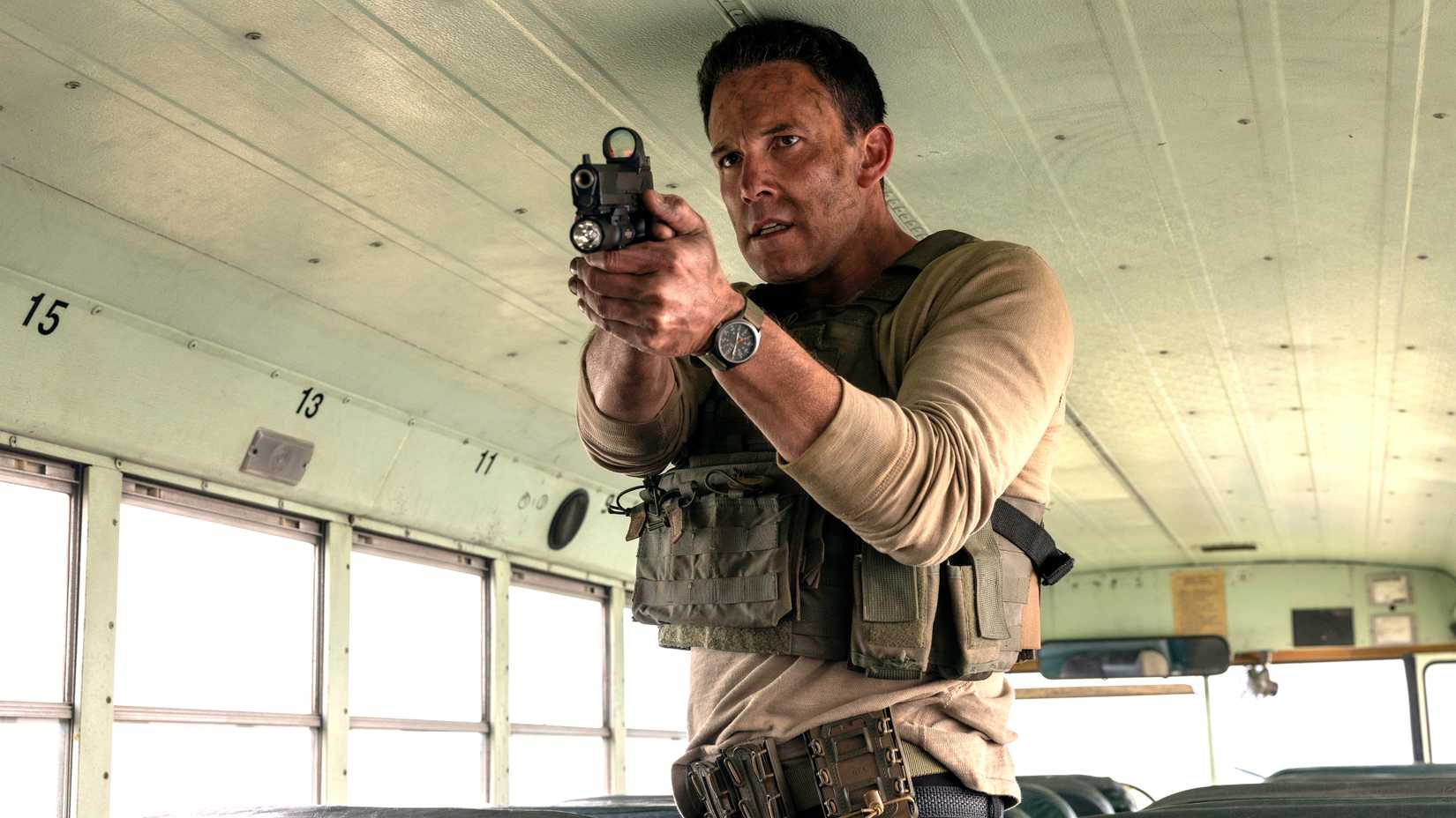 Ben Affleck's Christian looking intensely while aiming his pistol in a bus in The Accountant 2