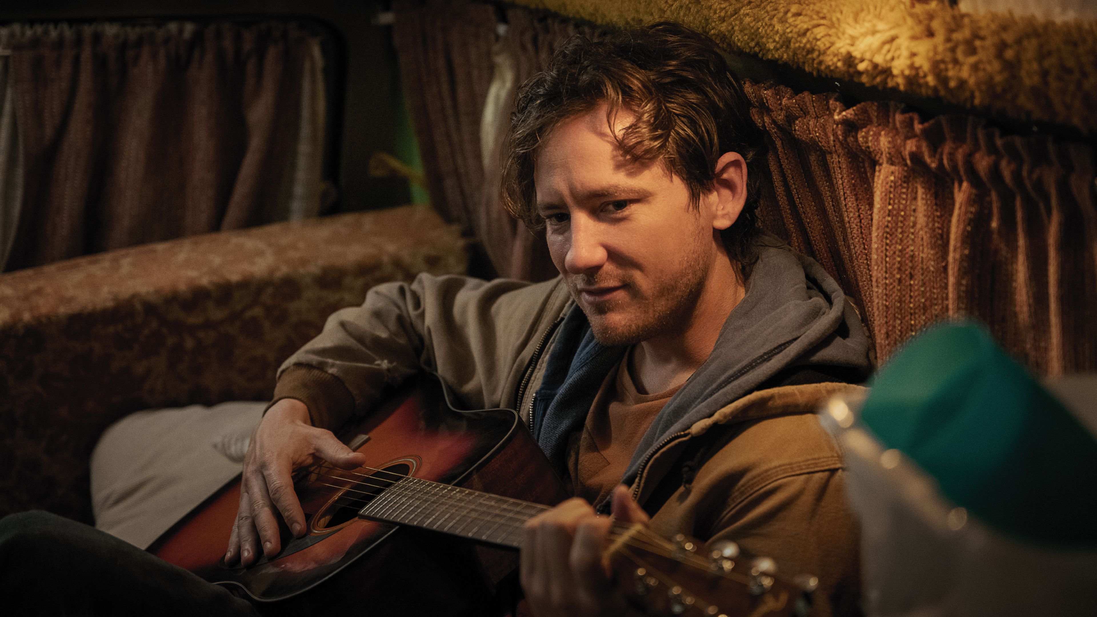 Cameron toca violão em cena de Remarkably Bright Creatures