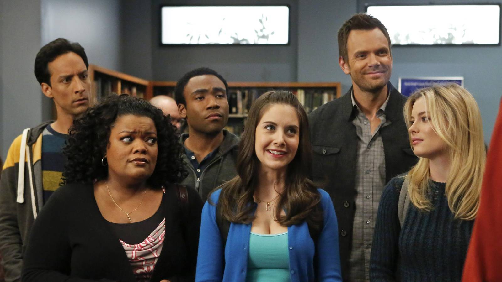 Annie smiling while Britta and Shirley look at her skeptically, Troy, Abed, and Jeff behind them.