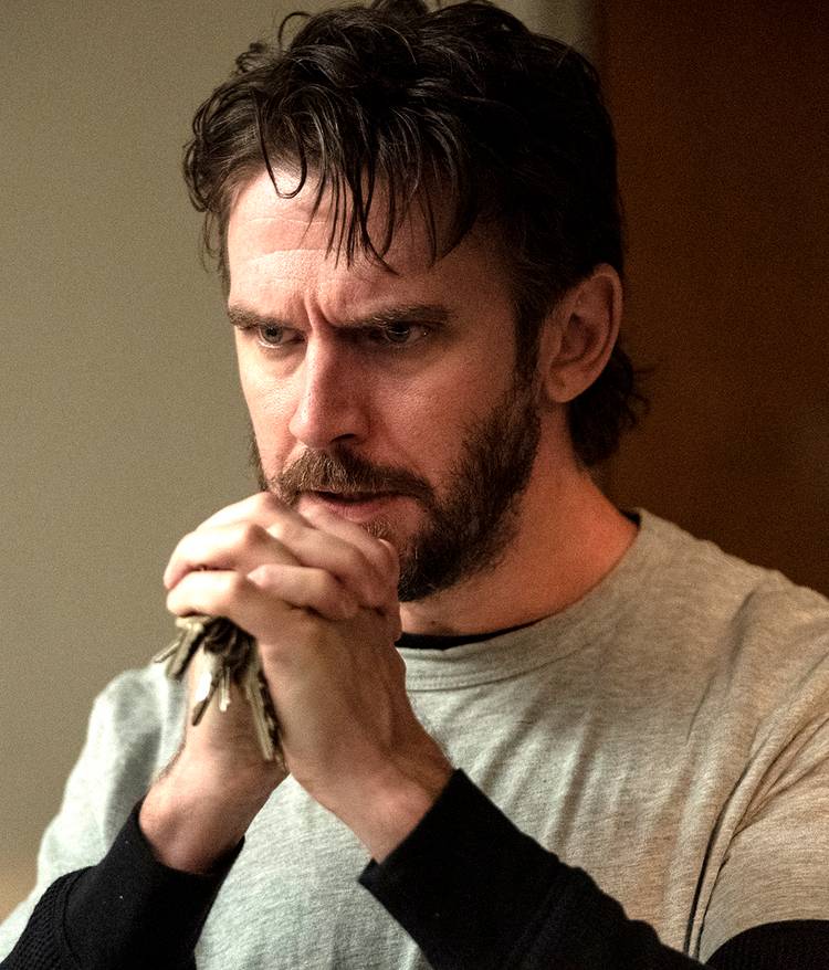 dan stevens pepper looking intensely while holding keys in his hands in the terror the devil in silver