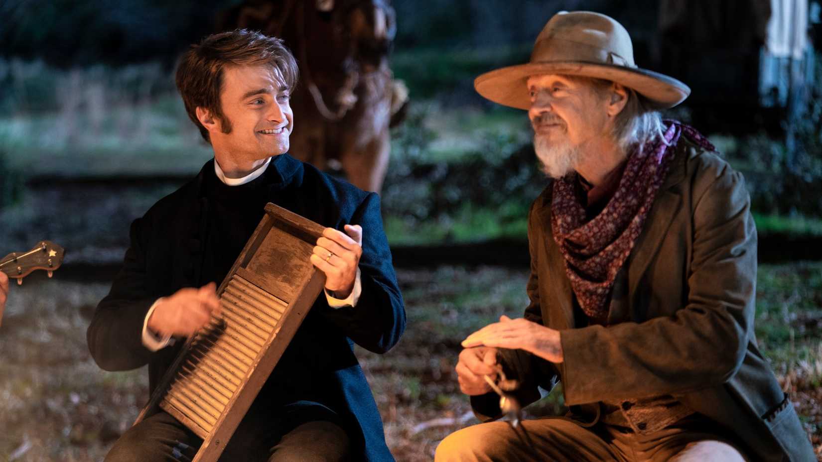 Daniel Radcliffe playing a washboard on the Oregon Trail while sitting next to Steve Buscemi in Miracle Workers