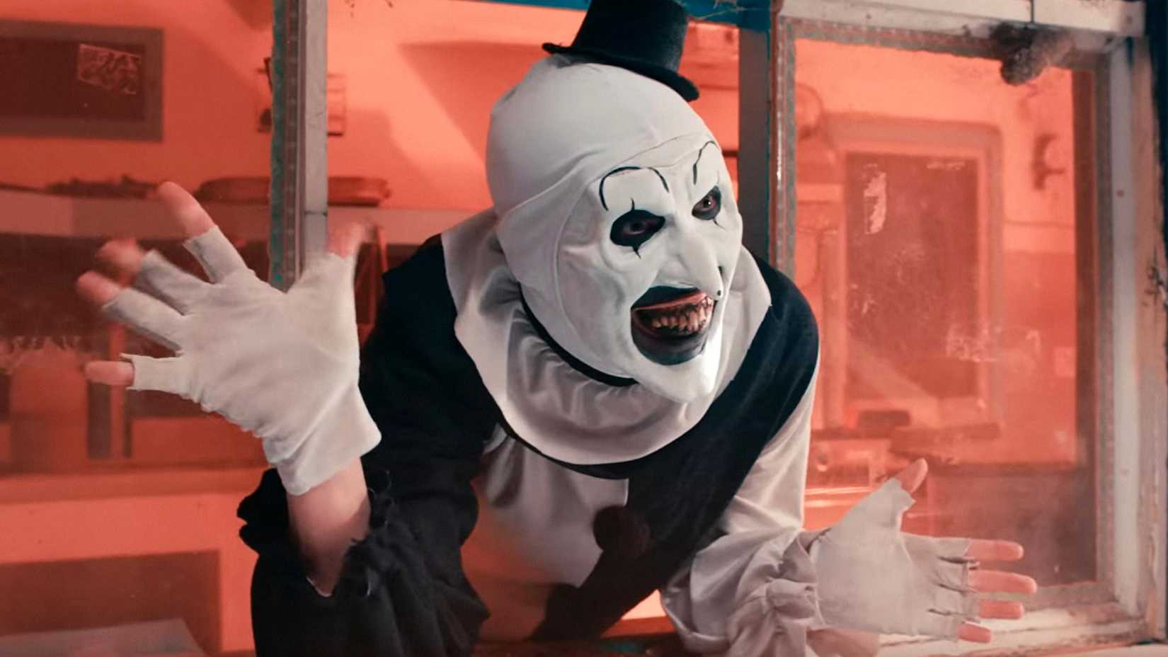 David Howard Thornton as Art the Clown leaning forward and spreading his hands in Terrifier 2