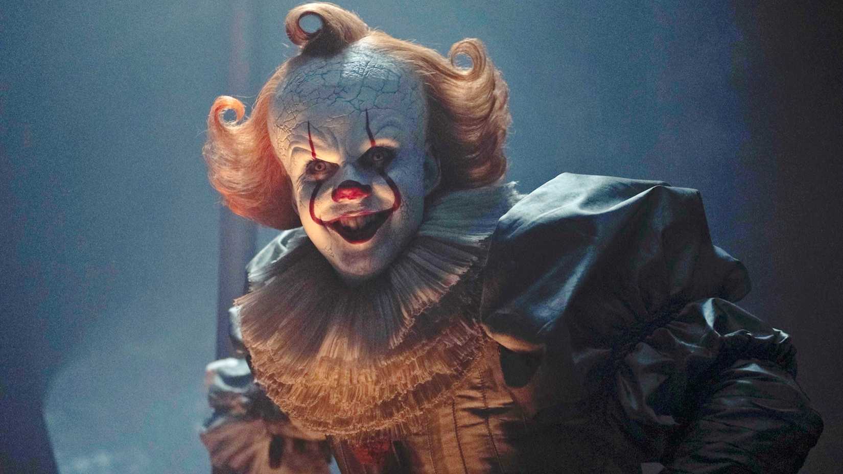 Bill Skarsgård‘s Pennywise smiling menacingly in It: Welcome to Derry