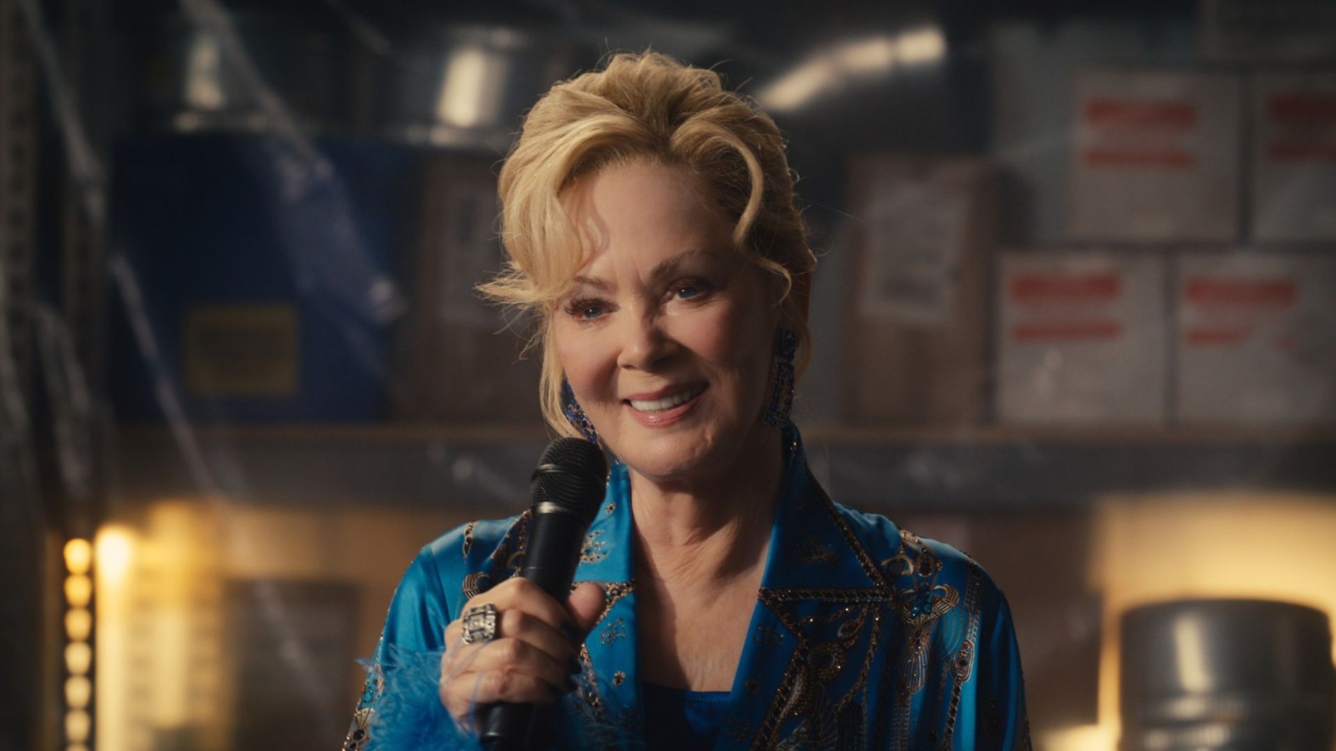Deborah Vance (Jean Smart) discursando em um armazém na quinta temporada de Hacks