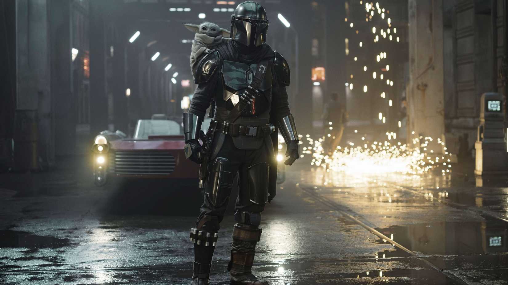 Din Djarin & Grogu standing in front of a speeder in The Mandalorian & Grogu