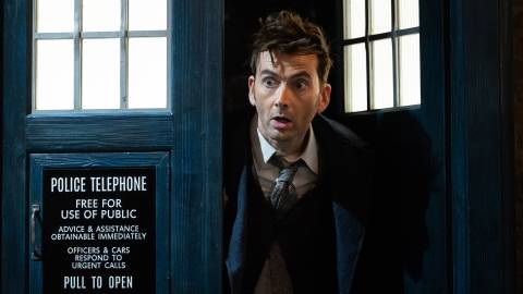 David Tennant's Fourteenth Doctor emerging out of the TARDIS with a surprised expression