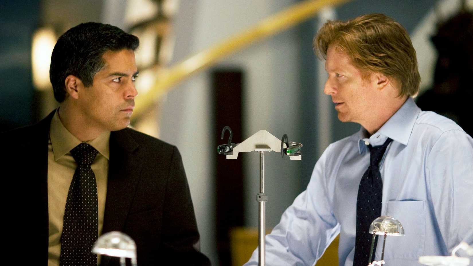 Esai Morales and Eric Stoltz speaking to each other in a Caprica scene