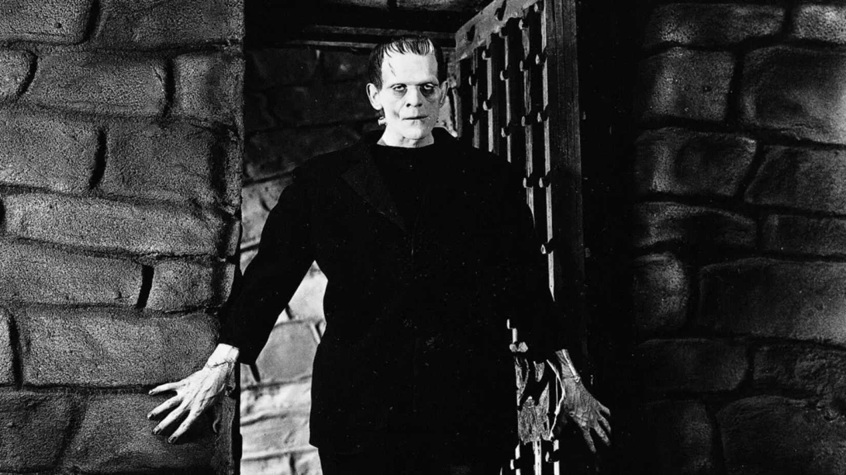 The Monster looms in a doorway in Frankenstein