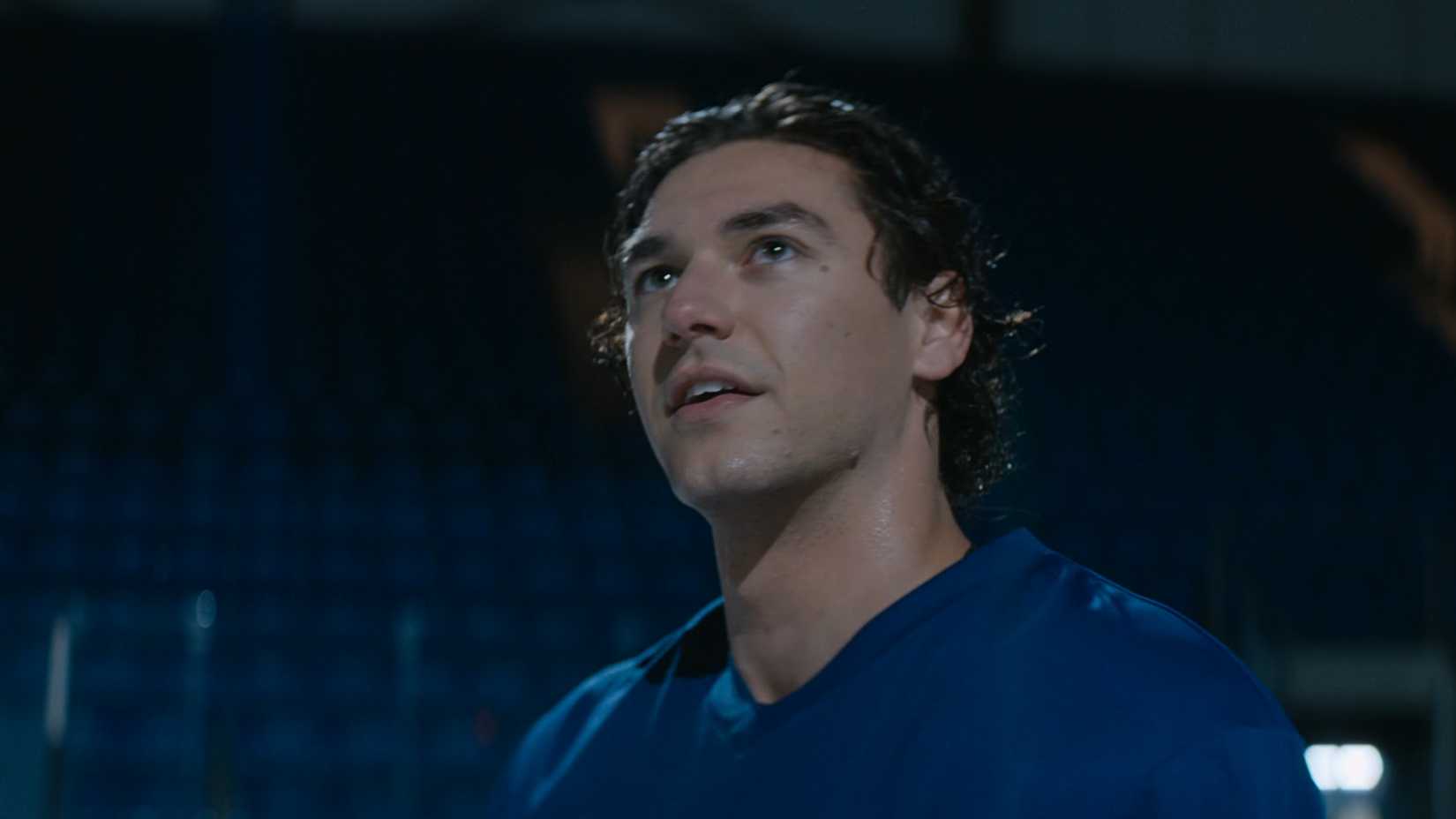 garrett looks up and smiles while in his hockey uniform in off campus season 1
