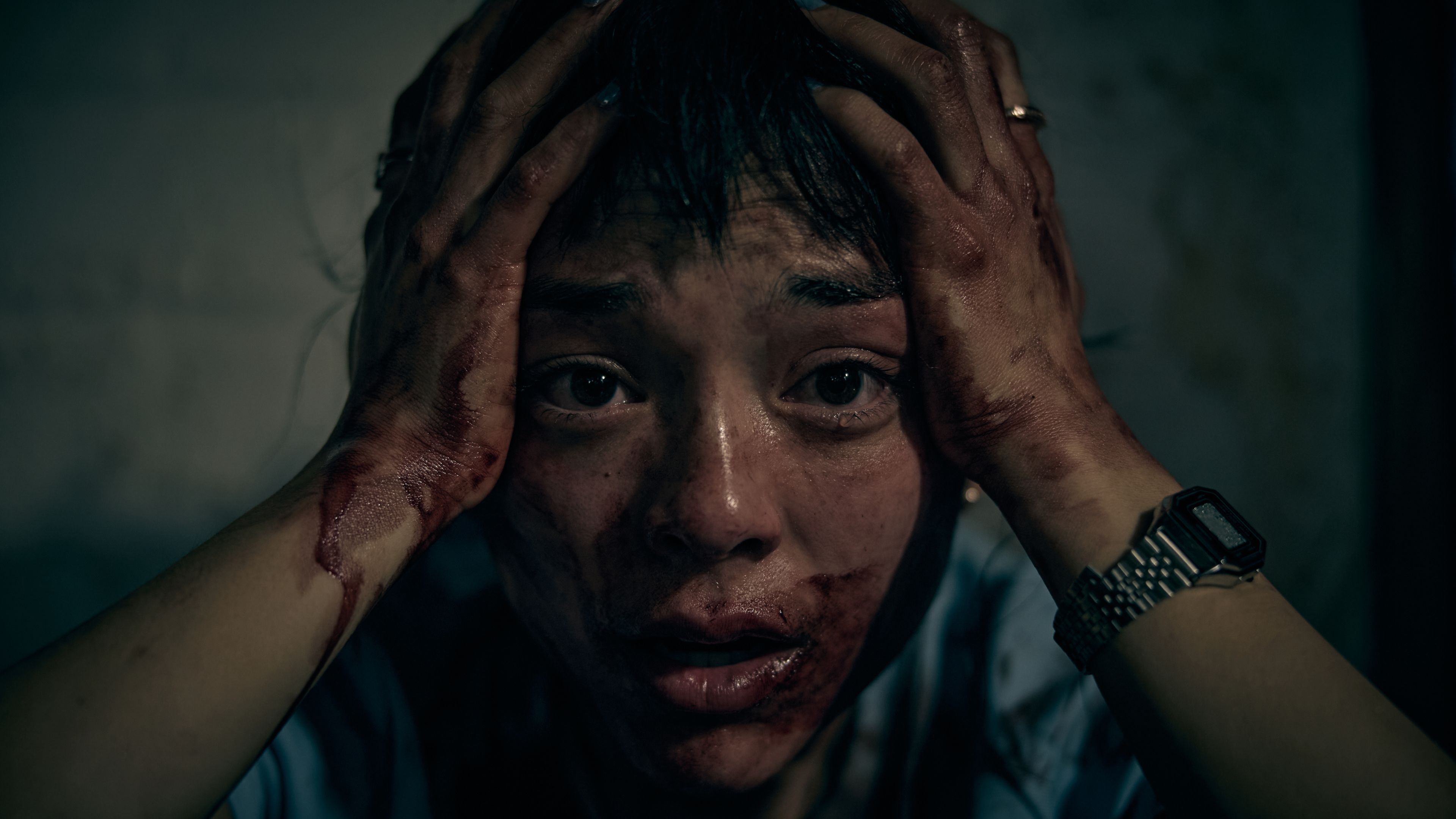 Hana with bloodied hands and face holding her head in horror in Saccharine