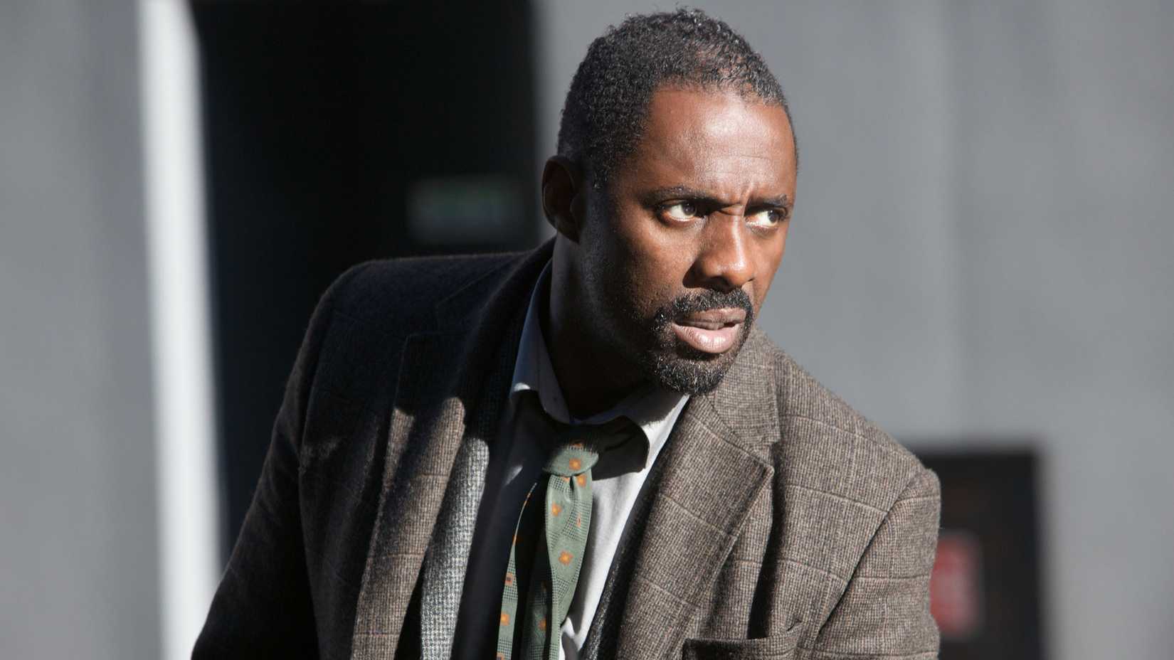 Idris Elba as John Luther looking at something in season 1 of Luther