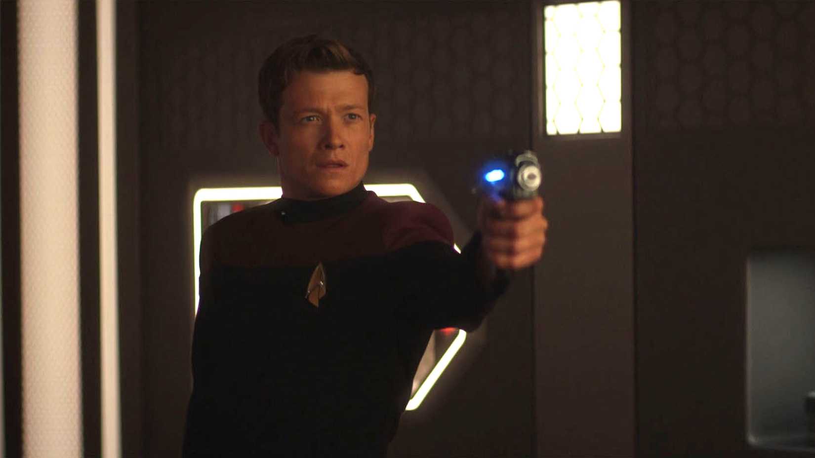 Jack Crusher aponta um phaser em cena de Star Trek: Picard