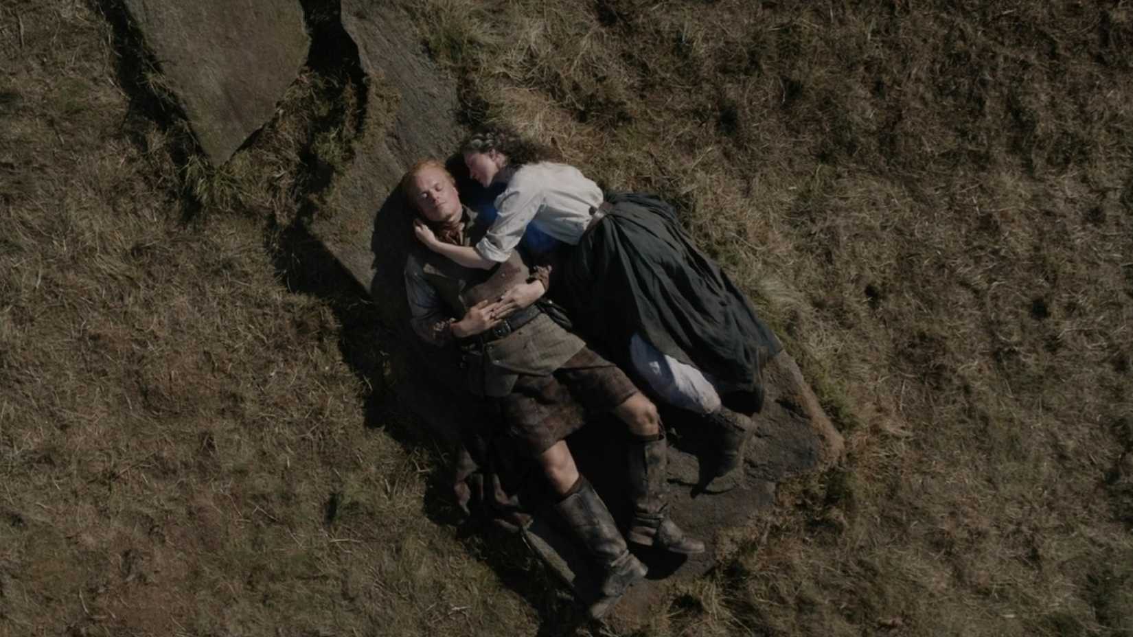 Jamie e Claire deitados sobre uma pedra em Outlander