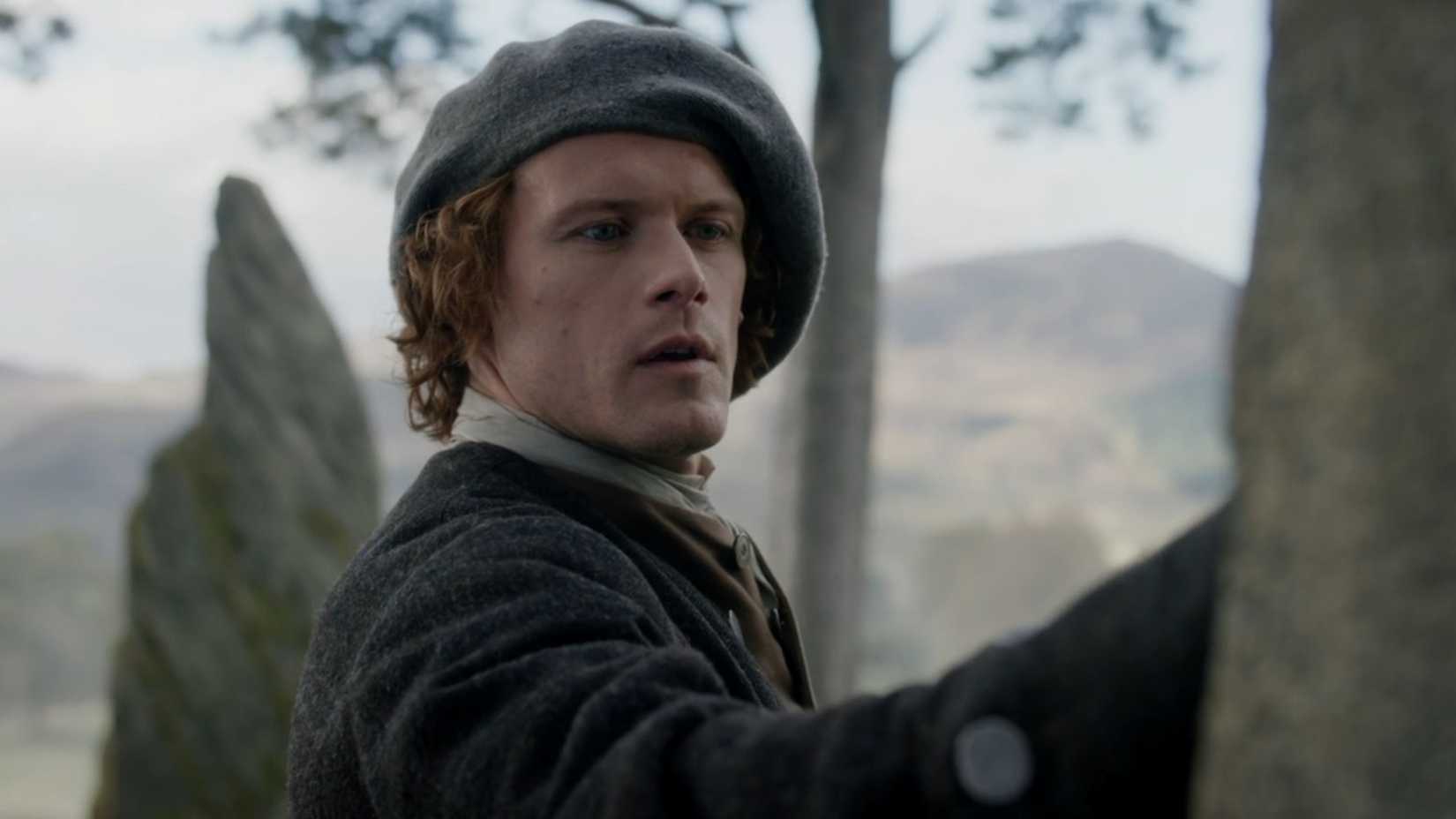 Jamie touching the standing stones at Craigh na Dun in Outlander
