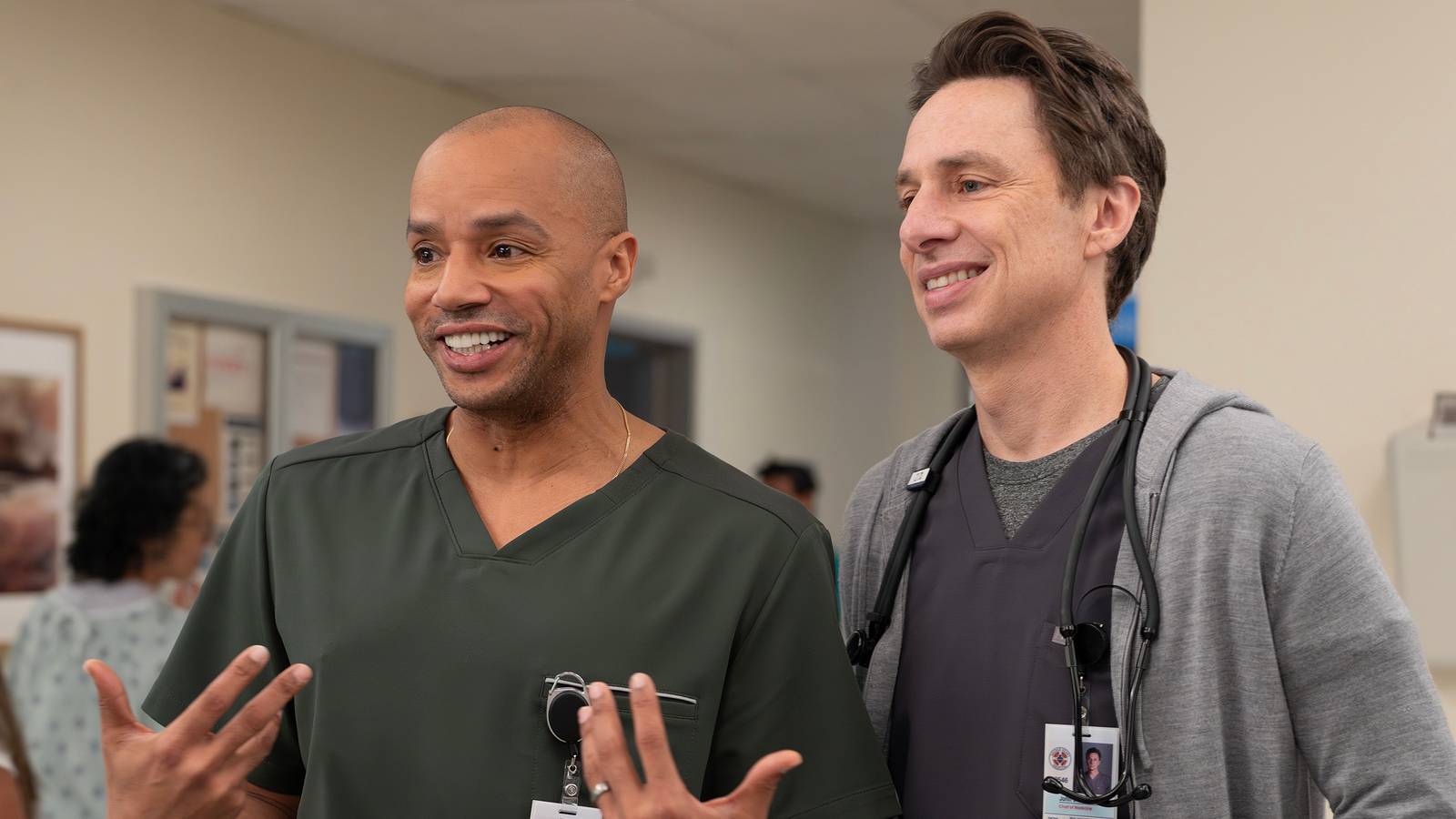 Turk and JD smiling in scrubs.