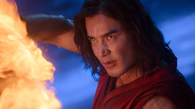 ludi lin s liu kang looking intensely while creating a flame from his hands in mortal kombat ii