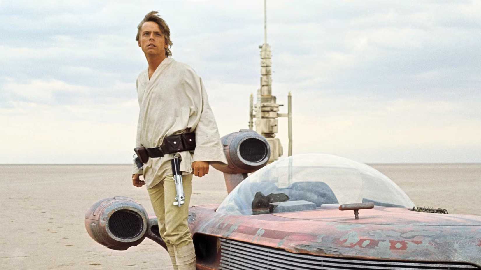 Luke Skywalker standing next to a speeder on Tatooine in A New Hope