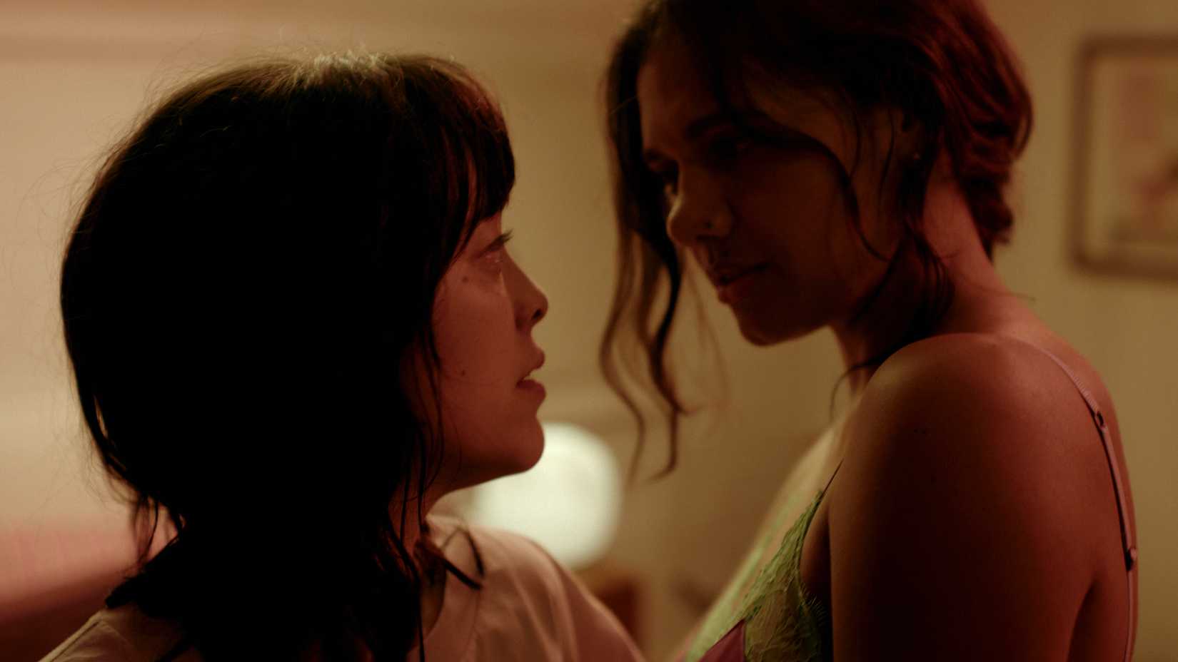 midori francis hana and madeleine madden s alanya with their faces close in a passionate moment in saccharine