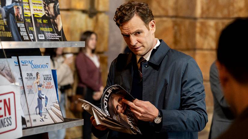 Nick Gehlfuss' Bill looking suspiciously up from a magazine in CIA season 1