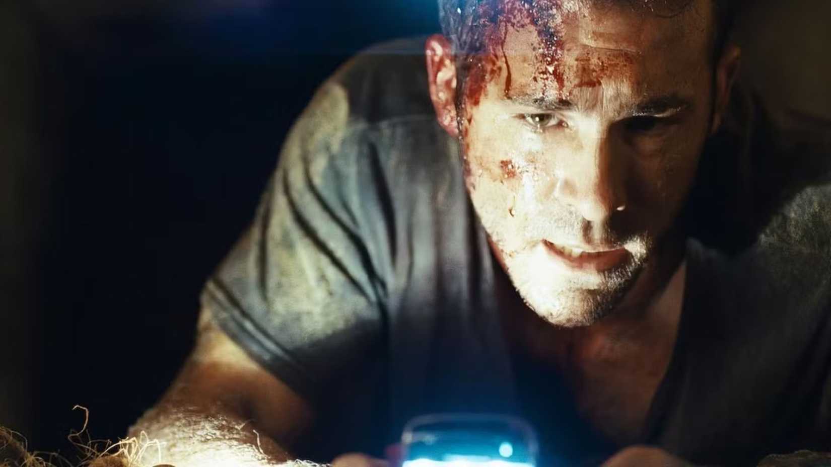 Ryan Reynolds as Conroy uses his phone light in Buried 2010