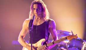 Sam Reid as Lestat on stage with a guitar in The Vampire Lestat