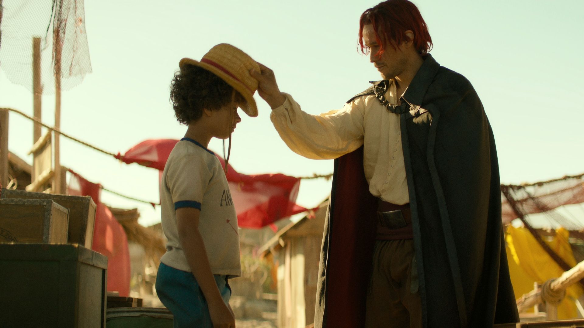 Shanks giving Luffy his Straw Hat in One Piece.