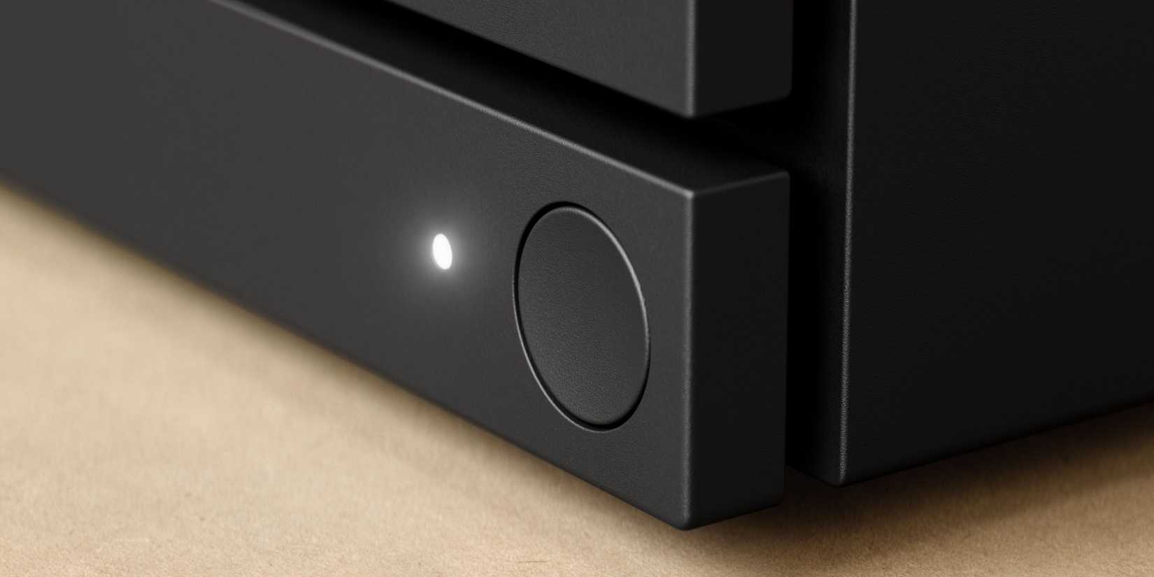 A closeup on the Steam Machine's power button. An indicator light is glowing white right next to it.