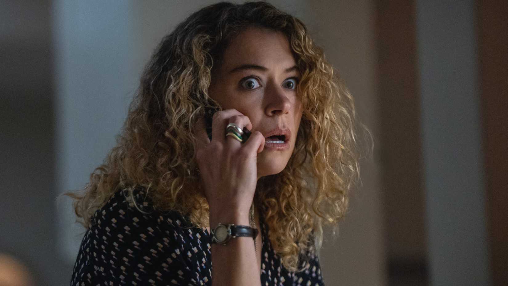 Tatiana Maslany as Paula on the phone and looking terrified in Maximum Pleasure Guaranteed