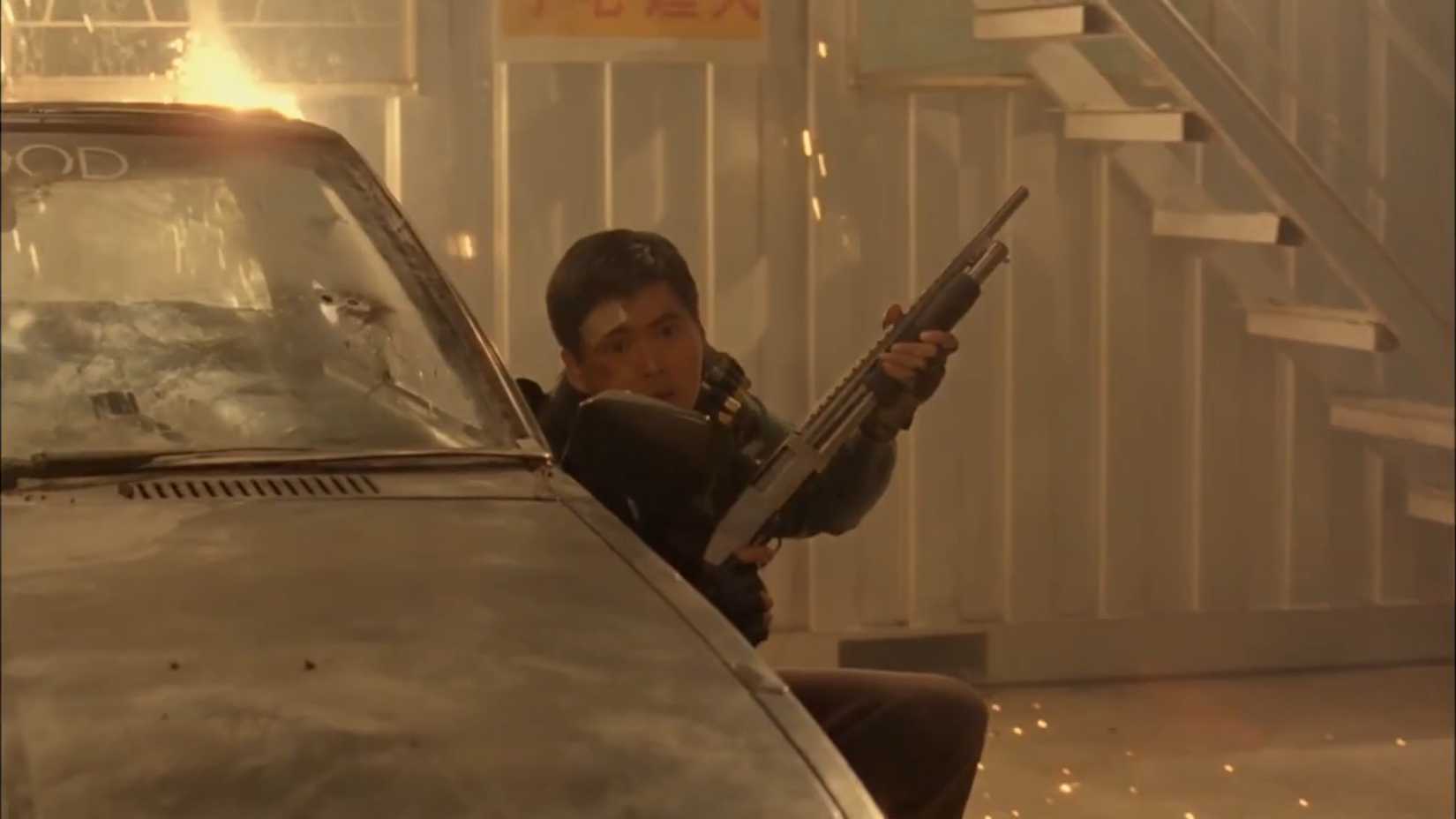 Tequila peeking over a broken car with a shotgun in Hard Boiled