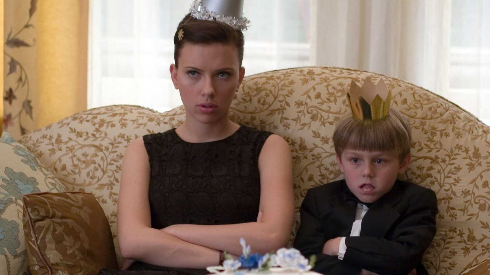 Annie looks grumpy on the couch with her charge in The Nanny Diaries
