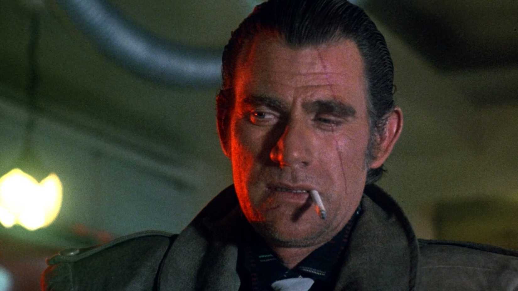 A man with a scar on his face smokes a cigarette in Trancers