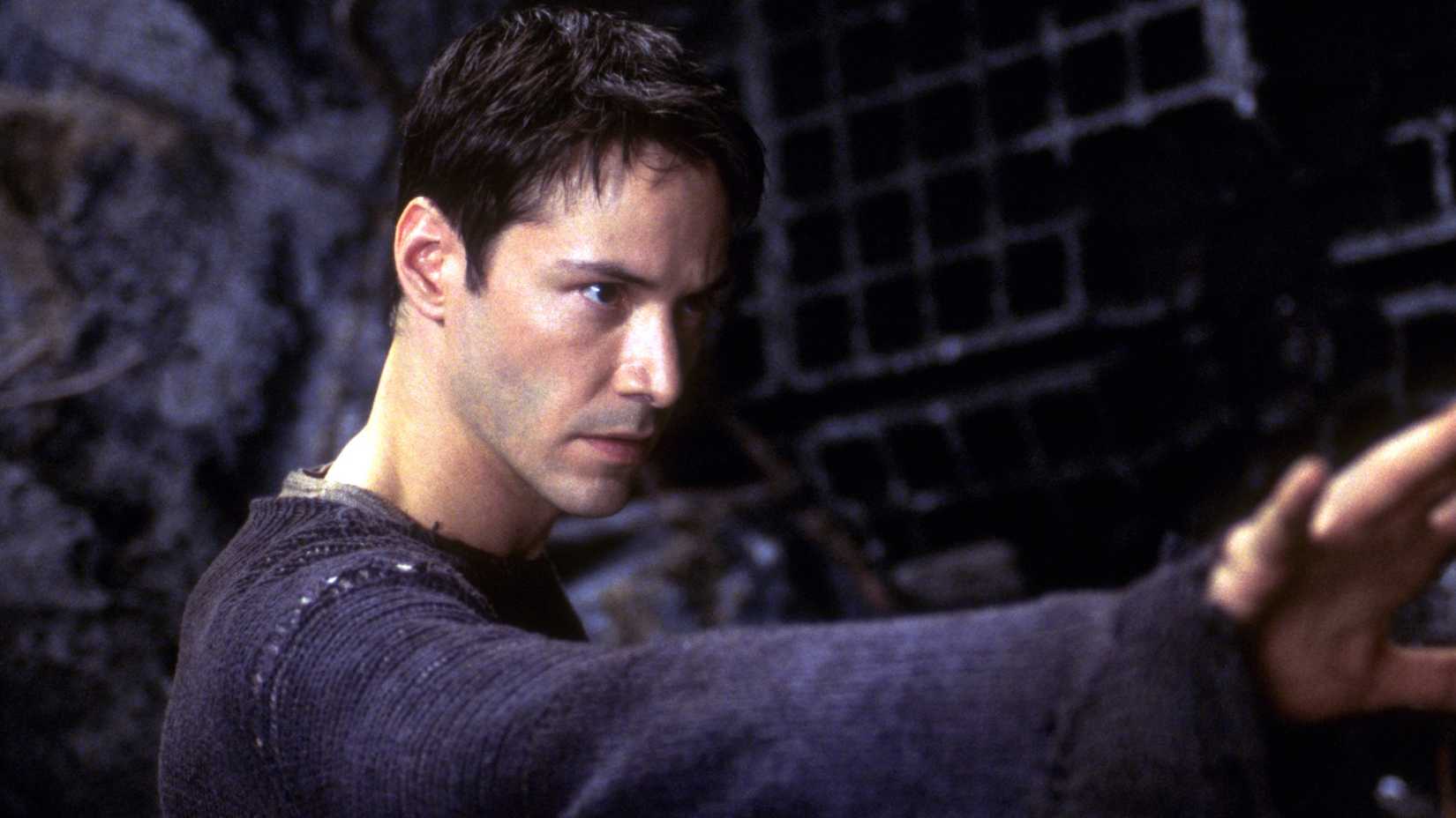 Keanu Reeves’ Neo with his right arm raised in The Matrix Reloaded